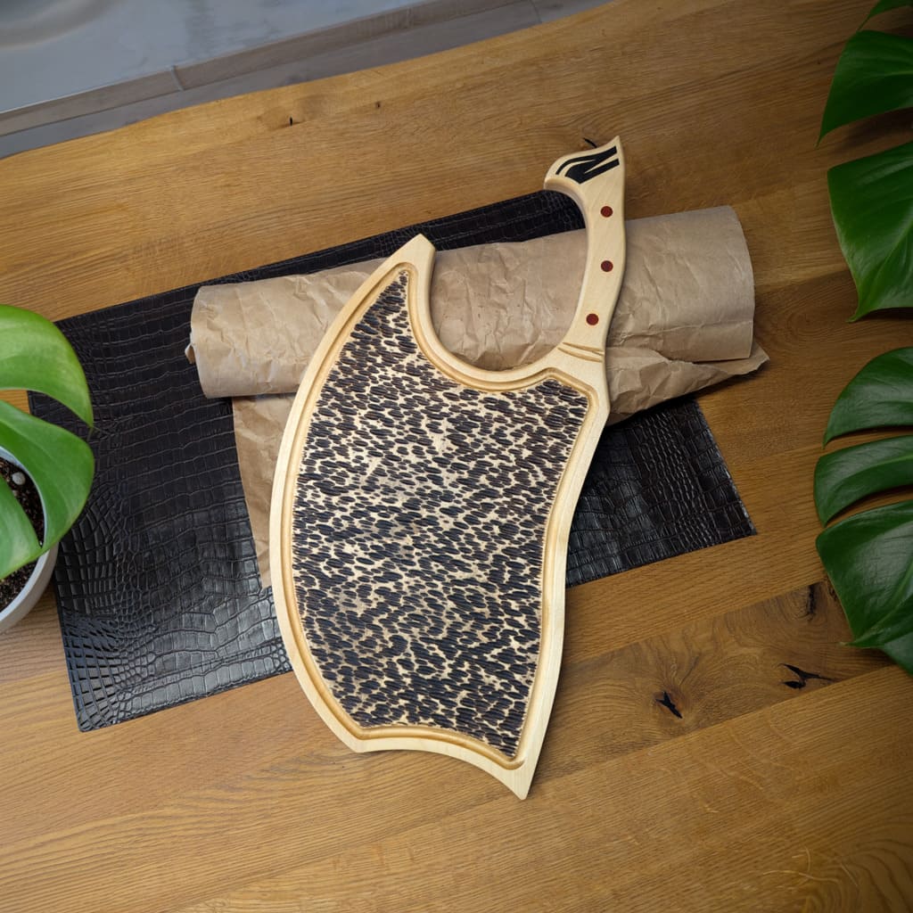 Die Steak-Seite eines Ahorn-Schneidebretts in Axtform mit Nussbaum Inlay